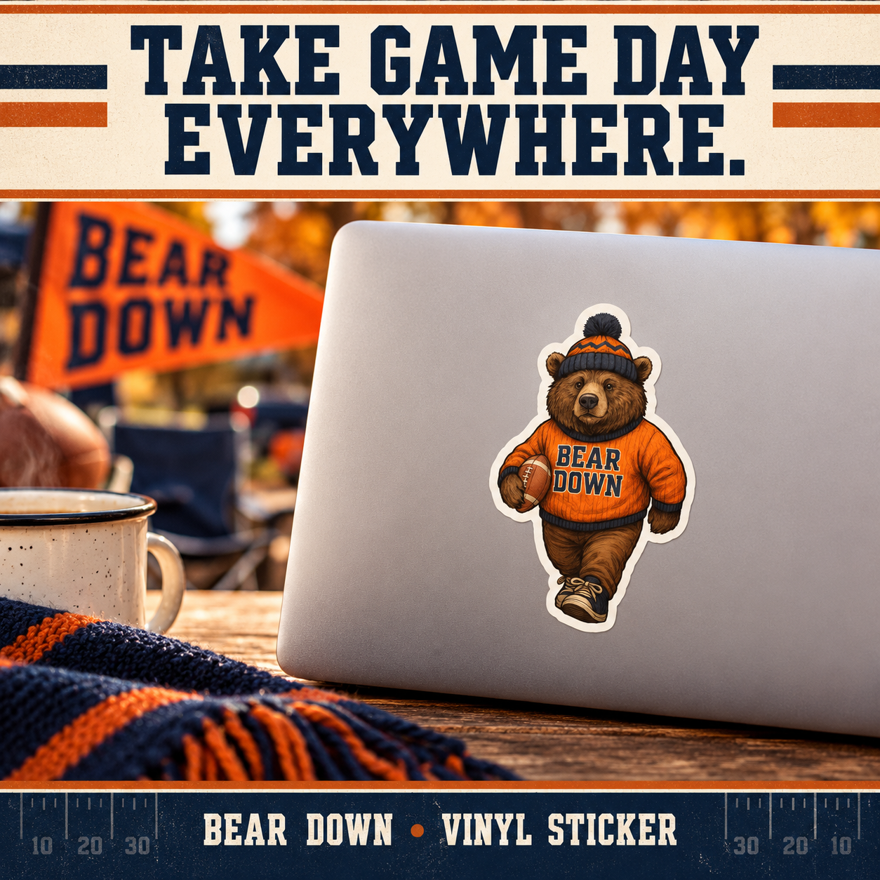 Bear Down bear sticker on a silver laptop at an autumn tailgate table with navy scarf and orange pennant.