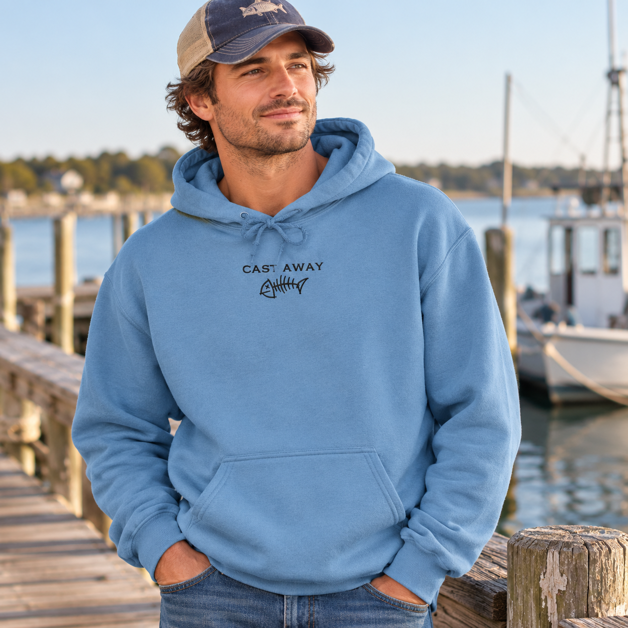Man wearing Denim Cast Away embroidered hoodie on a fishing pier