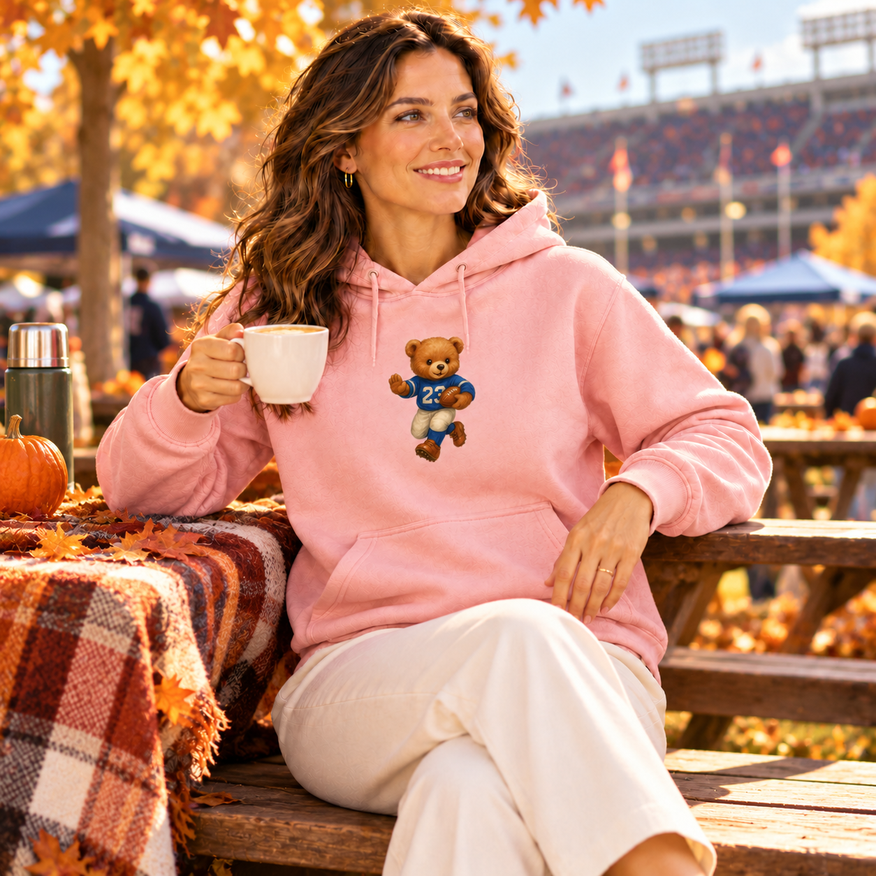 Woman wearing pink Football Bear Hoodie with coffee at fall tailgate