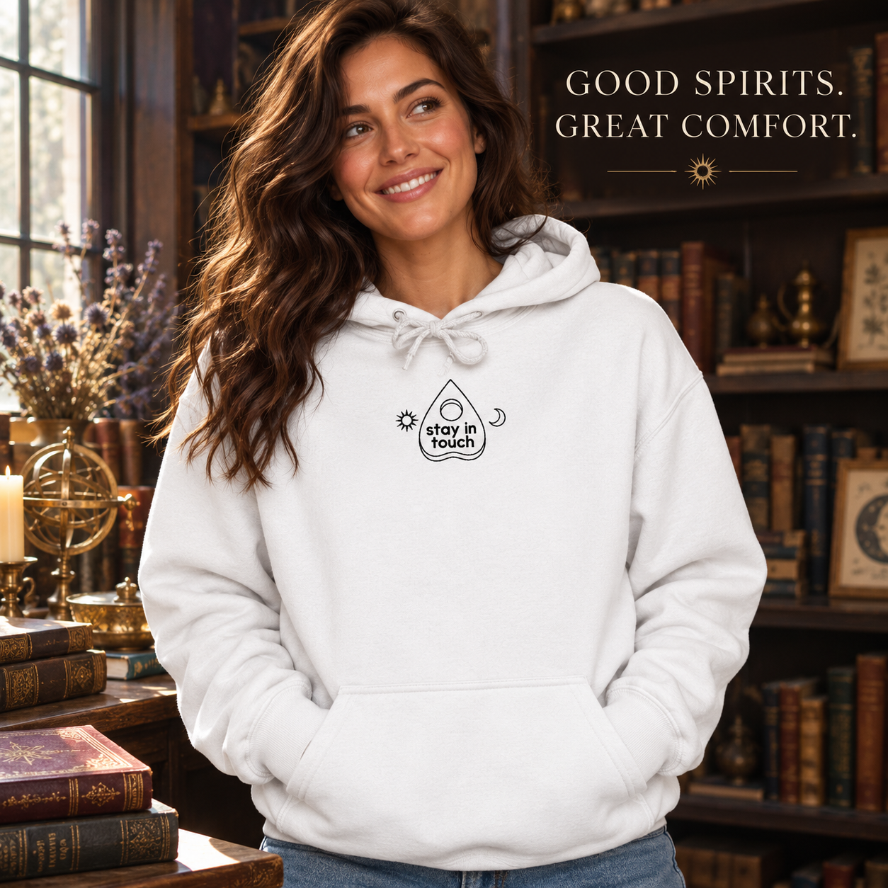 Stay in Touch white embroidered hoodie worn in a cozy bookshop